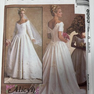 May include: McCall's pattern for a wedding dress. The cover features images of a bride in a white gown with long sleeves and a veil, and another with short sleeves. The pattern is labeled "Alicyn Exclusives" and "Petite-Able".