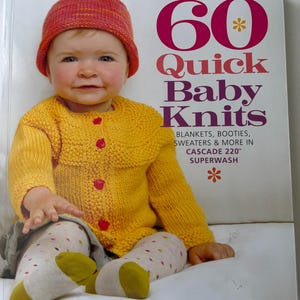 May include: A book titled 60 Quick Baby Knits featuring a cover image of a child wearing a bright yellow knitted cardigan with pink buttons, a variegated orange and pink beanie, and white tights with colorful dots, plus green and yellow socks.