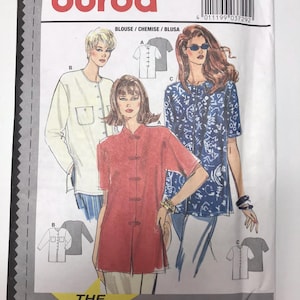 May include: Burda sewing pattern number 3729 for a blouse. The pattern includes three different styles: a white blouse with a mandarin collar, a red blouse with a mandarin collar, and a blue and white patterned blouse with a mandarin collar. The pattern includes instructions for seams and hems.