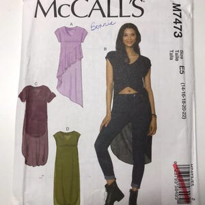 May include: McCall's sewing pattern M7473 showing four women's clothing designs. The pattern includes a top with a high-low hem, a dress with a draped skirt, and a sleeveless dress. Size E5 (14-16-18-20-22).