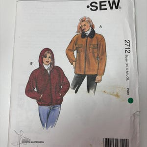 May include: A Kwik Sew pattern envelope 2712 for sizes XS-S-M-L-XL. The front shows two illustrations: a tan jacket with a dark collar and a maroon hooded jacket with a drawstring. Text includes Pattern 2712, Kwik Sew, and company address details.