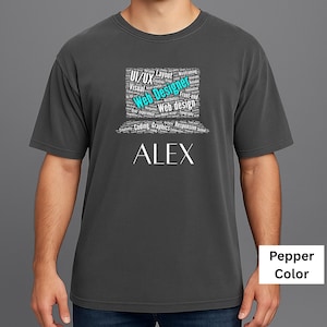May include: Pepper-colored t-shirt with the name "ALEX" in white block letters. Above the name is a square graphic with the words "Web Designer" in teal, surrounded by related terms like "UI/UX," "Coding," and "Graphics."