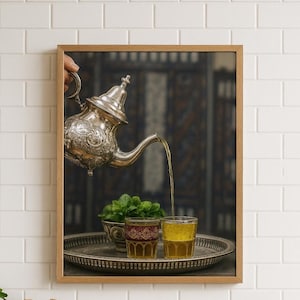 May include: A framed image of a silver teapot pouring tea into two glasses on a silver tray. A small bowl of mint sits next to the glasses. The background is a dark, patterned design.