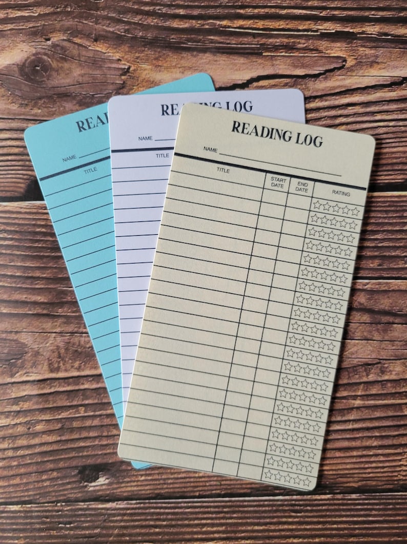 May include: Three reading log cards, one blue, one white, and one ivory. The ivory card has the words 'Reading Log' printed at the top. The cards have lines for writing the name, title, start date, end date, and rating of the book. The rating is indicated by five stars.