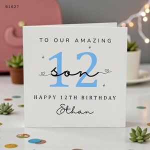 Könnte beinhalten: Eine quadratische weiße Grußkarte mit dem Text TO OUR AMAZING, einer großen hellblauen Zahl 12, dem Wort son in schwarzer Schreibschrift und dem Text HAPPY 12TH BIRTHDAY Ethan. Das Design enthält kleine schwarze Stern- und Herzsymbole.