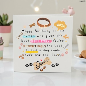 Peut inclure: Carte de joyeux anniversaire blanche sur le th&egrave;me des chiens. La carte pr&eacute;sente un collier de chien marron, des empreintes de pattes et le texte "Happy Birthday to the human who gives the best belly rubs!" La carte est d&eacute;cor&eacute;e d'illustrations d'os et d'empreintes de pattes.
