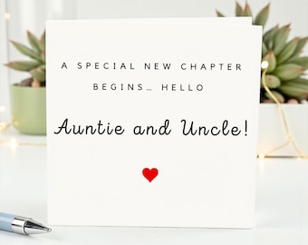 May include: A white greeting card with the text "A SPECIAL NEW CHAPTER BEGINS... HELLO Auntie and Uncle!" in black. A small red heart is at the bottom. The card is on a white surface with a pen and a succulent plant in the background.