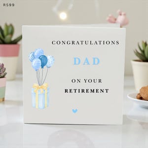May include: A white greeting card with the words "Congratulations Dad On Your Retirement" in black and blue text. The card features a watercolor illustration of blue balloons and a gift box with a yellow bow.