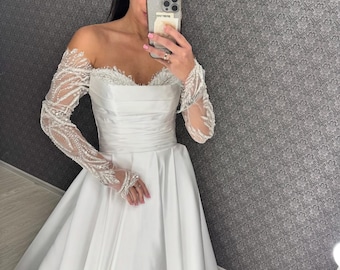 Vestido de novia de satén color marfil con hombros descubiertos: corte en A con corsé y mangas de encaje reflectante