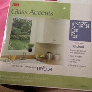 May include: A package of 3M Glass Accents, featuring a floral vine design. The package includes four 6" x 6" (15.2 cm x 15.2 cm) designs, a soap solution packet, and a squeegee. The product creates the look of etched glass.