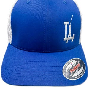 Op de afbeelding: Een blauwe Flexfit baseballpet met een witte mesh achterkant. De pet heeft een wit geborduurd logo op de voorkant en een Flexfit sticker op de klep. Een klassieke pet.