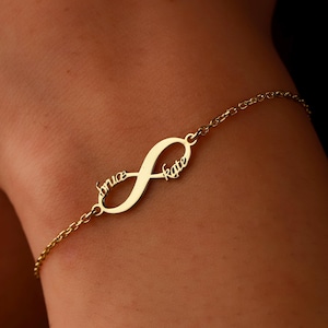 May include: Gold infinity bracelet with the names "Bruce" and "Kate" engraved on it.