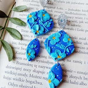 Handmade polymer clay drop earrings with blue flowers, glitter, & silver hooks. Sparkly, lightweight, and unique floral statement jewelry