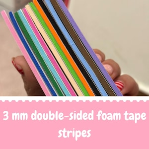 Könnte beinhalten: Ein Stapel von 3 mm doppelseitigen Schaumstoffklebebandstreifen in verschiedenen leuchtenden Farben wie Pink, Blau, Grün, Orange, Schwarz und Lila. Die rechteckigen Schaumstoffstreifen sind übereinandergelegt und zeigen ihre Dicke.