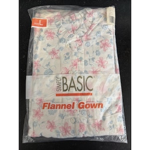 May include: A white flannel gown with a floral pattern in pink and blue, packaged in a clear plastic bag. The gown is labeled "Simply Basic" and "Flannel Gown". The size is marked as "L".