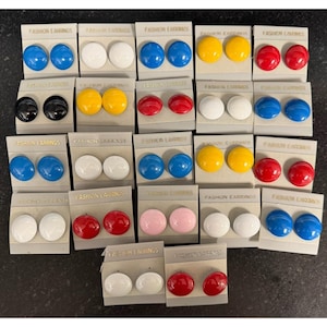 May include: A collection of round stud earrings displayed on individual white cards labeled FASHION EARRINGS. The earrings feature a smooth, glossy finish in various solid colors including red, blue, yellow, white, black, and light pink.