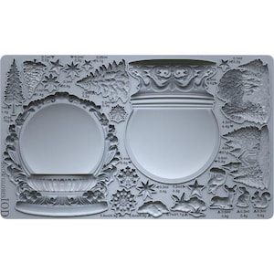 May include: A grey silicone mould with designs for snow globes. The mould includes shapes of snow globes, trees, stars, snowflakes, and woodland creatures. The text "SNOW GLOBES IOD" is visible on the mould.