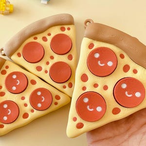 Puede incluir: Tres porciones de pizza con ingredientes de pepperoni. Las porciones de pizza tienen una base amarilla, corteza marrón y pepperoni rojo con detalles blancos. Las porciones de pizza están dispuestas sobre una superficie amarillo claro.