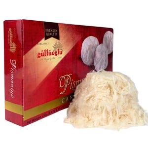 May include: A box of Güllüoğlu Baklavacı Pistmaniye Candy, a Turkish dessert made of spun sugar, with a net weight of 250 grams (8.8 oz). The box is red with gold lettering and features the company logo. The candy is white and fluffy.