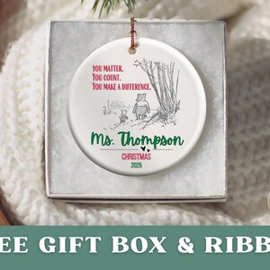 May include: A white ceramic Christmas ornament with a Winnie the Pooh illustration and the text "YOU MATTER. YOU COUNT. YOU MAKE A DIFFERENCE." The ornament is personalized with "Ms. Thompson" and "CHRISTMAS 2025."