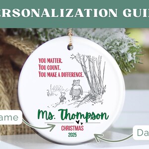 May include: A white ceramic Christmas ornament with a gold string for hanging. The ornament features a Winnie the Pooh illustration and the text "YOU MATTER. YOU COUNT. YOU MAKE A DIFFERENCE." It is personalized with a name and the year 2025.