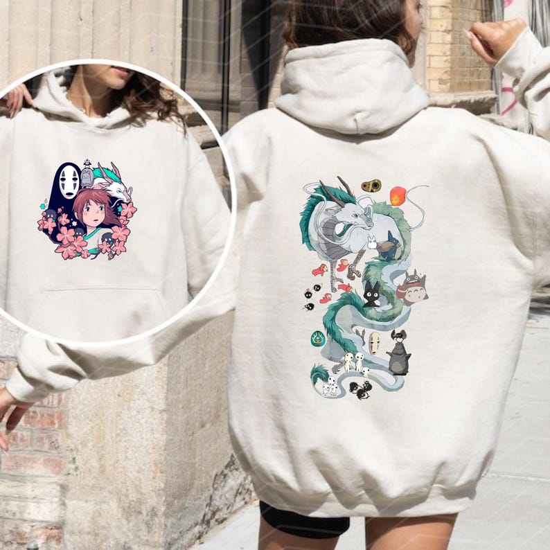 May include: A beige hoodie with anime-style illustrations on the front and back. The front design features a girl, a dragon, and other characters. The back displays a dragon and other characters in a vertical arrangement.