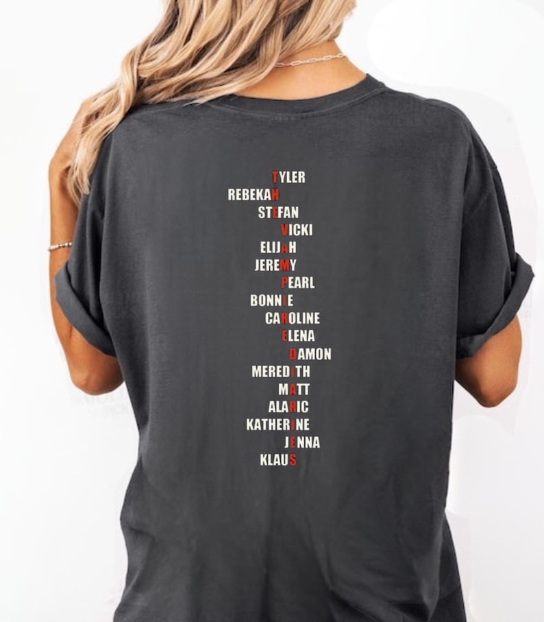 Puede incluir: Camiseta gris oscuro con una lista de nombres en fuente roja y blanca. Los nombres incluyen Tyler, Rebekah, Stefan, Vicki, Elijah, Jeremy, Pearl, Bonnie, Caroline, Elena, Damon, Meredith, Matt, Alaric, Katherine, Jenna y Klaus.