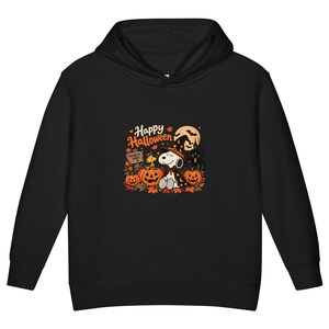 May include: A black hooded sweatshirt featuring a graphic print of Snoopy and Woodstock dressed in Halloween costumes. The design includes orange pumpkins, autumn leaves, a full moon, and the text Happy Halloween and Peanuts Vibes.