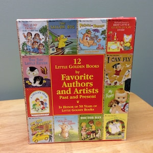 May include: A collection of 12 Little Golden Books by Favorite Authors and Artists, Past and Present. The box features a red background with gold trim and illustrations from each book. The title "12 Little Golden Books by Favorite Authors and Artists, Past and Present" is printed in yellow on the front of the box. The text "In Honor of 50 Years of Little Golden Books" is printed in yellow at the bottom of the box.