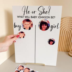 Op de afbeelding: Een wit bord met de tekst "He or She? WHAT WILL BABY JOHNSON BE?" toont foto's van kinderen. Het woord "boy" staat links en "girl" rechts. Een hand plaatst een fotosticker.