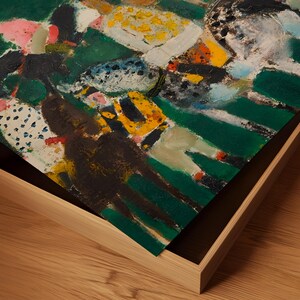 May include: Abstract painting of a horse race, with jockeys in yellow, white, and black. The artwork is framed in a light wood frame, with a green background and splashes of color.