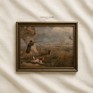 May include: A framed landscape print titled VINTAGE GLOW PRINTS featuring an oil painting of a hunter in a dark coat and hat aiming a rifle at birds in flight. Two hunting dogs run through tall grass near a large tree in a marshy field.