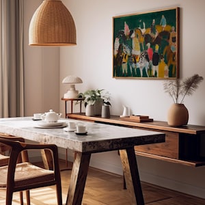 May include: A dining room scene featuring a marble-topped table with wooden legs and chairs. A woven pendant light hangs above. A painting with figures on horses hangs on the wall. A wooden sideboard and decorative items complete the scene.