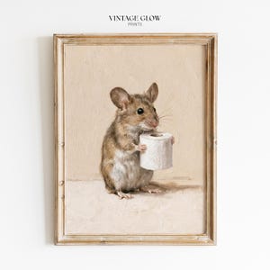 May include: A framed wall art print titled VINTAGE GLOW PRINTS featuring an oil painting of a brown mouse holding a white roll of toilet paper. The mouse has large ears, dark eyes, and light-coloured fur on its belly, set against a neutral beige background.