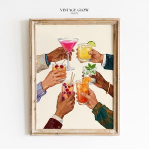 May include: A framed print depicting a toast with cocktails. The image shows hands holding up a variety of colourful drinks, such as a pink martini, a yellow cocktail with lime, and a drink with cherries. The text "VINTAGE GLOW PRINTS" is at the top of the print.