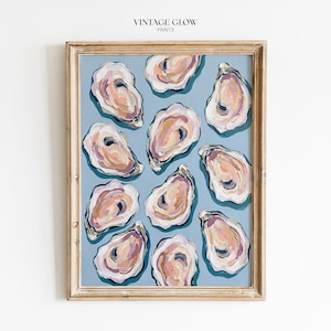 May include: A framed print with an abstract oyster painting. The artwork depicts multiple oyster shells in pink, cream, and peach hues on a light blue backdrop. The frame is a light, natural wood colour. The text "VINTAGE GLOW PRINTS" is at the top.