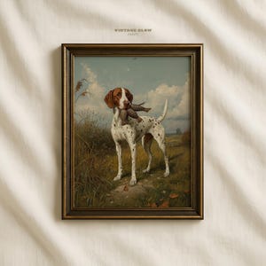 May include: Framed vintage print featuring a hunting dog with brown and white markings, holding a bird in its mouth. The artwork is set in a field with a cloudy sky, and the frame has a gold finish. The text "VINTAGE GLOW PRINTS" is at the top.