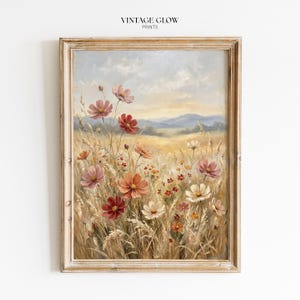Può includere: Dipinto incorniciato di un paesaggio floreale con fiori di campo rosa, rossi e bianchi. L'opera d'arte ha un'estetica vintage, con una palette di colori tenui e un'atmosfera calda. Il testo "VINTAGE GLOW PRINTS" è in alto.