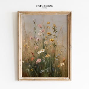 May include: A framed wall art print titled VINTAGE GLOW PRINTS featuring an oil painting of a wildflower meadow. The artwork displays a variety of yellow, pink, and white flowers mixed with tall green grasses against a soft, muted grey background.