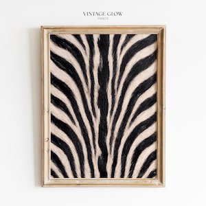 May include: A rectangular wall art print featuring a high-contrast black and white zebra stripe pattern encased in a light-toned wooden frame. The text VINTAGE GLOW PRINTS is centred above the framed artwork on a plain white background.