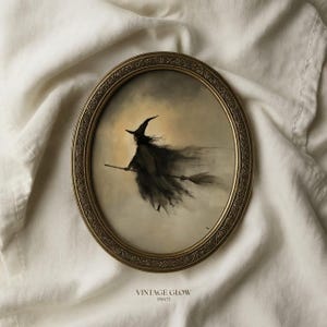 May include: An oval-shaped wall art print in an ornate gold frame featuring a dark, painterly illustration of a witch flying on a broomstick against a pale, glowing background. The text VINTAGE GLOW PRINTS is printed in small letters at the bottom.