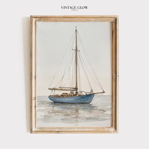 May include: Watercolor painting of a blue sailboat on calm water, framed in a light wood frame. The artwork features a detailed depiction of the boat with its masts and rigging, reflecting in the water. The text "VINTAGE GLOW PRINTS" is at the top.