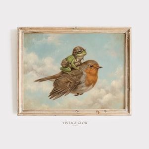 May include: A framed print featuring a whimsical illustration of a frog wearing a vintage aviator helmet and goggles, riding on the back of a robin. The artwork is set against a cloudy sky background, with the text "VINTAGE GLOW PRINTS" at the bottom.