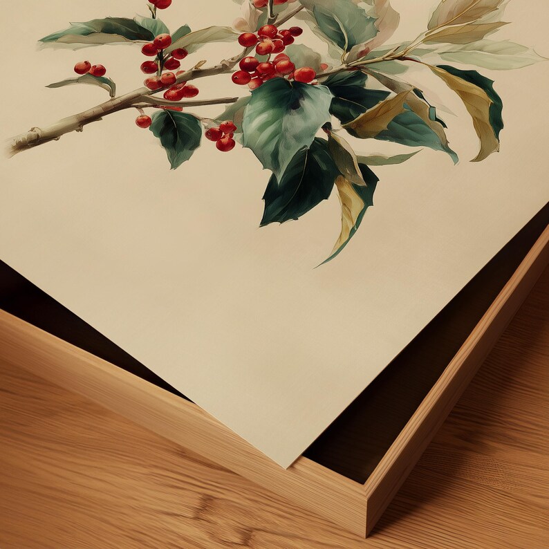 May include: Watercolor painting of a holly branch with red berries and green leaves. The artwork is framed in a light-colored wooden frame, set against a neutral background. The painting captures the natural beauty of the plant.
