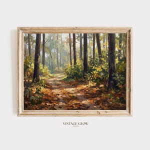 May include: A framed landscape painting of a forest path. The artwork features tall trees, a path covered in fallen leaves, and sunlight filtering through the trees. The frame is a light wood color. The text "VINTAGE GLOW PRINTS" is at the bottom.
