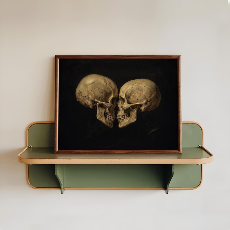 K&ouml;nnte beinhalten: Ein rechteckiger gerahmter Druck mit zwei menschlichen Sch&auml;deln, die sich vor einem einfarbigen schwarzen Hintergrund gegen&uuml;berstehen. Die Sch&auml;del sind in Beige- und Cremet&ouml;nen gehalten. Das Kunstwerk befindet sich in einem dunkelbraunen Holzrahmen.