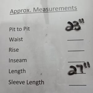 May include: White paper with handwritten measurements. The text reads "Approx. Measurements" with "Pit to Pit" and a measurement of 23 inches. "Length" is listed with a measurement of 27 inches.