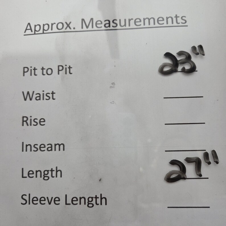 May include: White paper with handwritten measurements. The text reads "Approx. Measurements" with "Pit to Pit" and a measurement of 23 inches. "Length" is listed with a measurement of 27 inches.