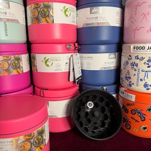 May include: A collection of 18oz Hydrapeak Foodie stainless steel insulated food jars in various colors including pink, blue, mint green, and orange. Some jars feature floral, bow, or motorcycle patterns, while others have labels showing food images.