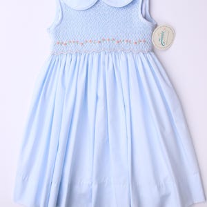Smocked hand embroidered girls dress -Baby blue sleeveless dress with a bow in the back and hand embroidered pink flower on the front.
